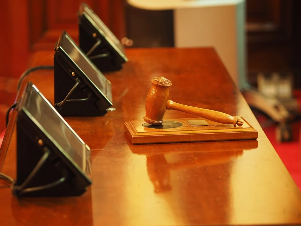 a wooden gavel on a table with a few tablets